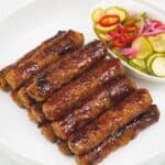 Skinless Longganisa with pickled vegetables on a plate.