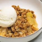 Apple Crisp on a plate with ice cream.