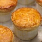 Individual portions of chicken pot pie on a parchment paper-lined board.