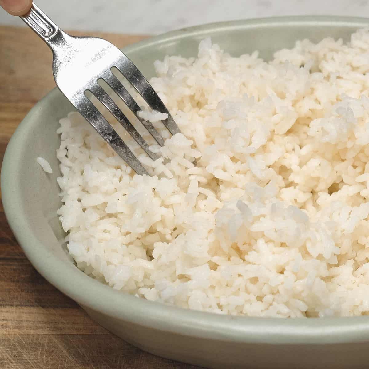 Fluffing the rice with a fork.