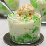 Buko Pandan on a glass dish cup topped with ice cream covered be rice crisps.