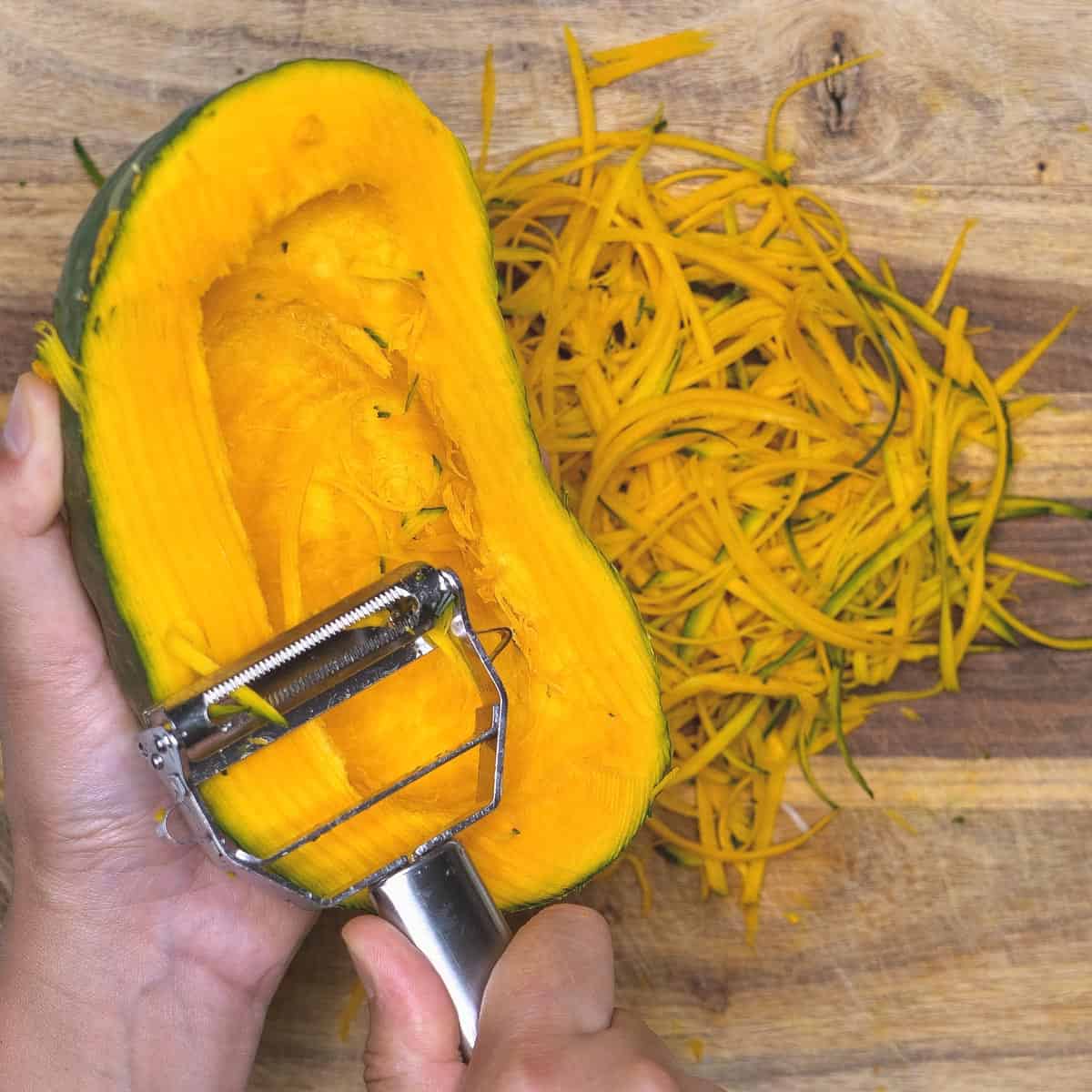 Making thin strips of kabocha squash using a julienne peeler.
