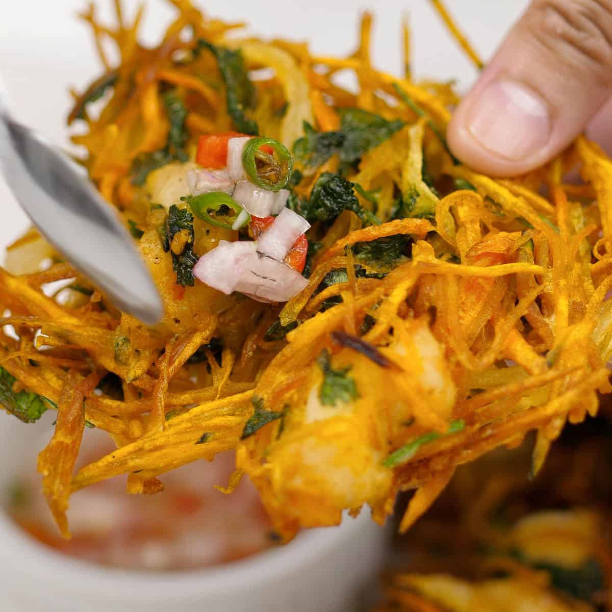 Adding spiced vinegar to fried ukoy.