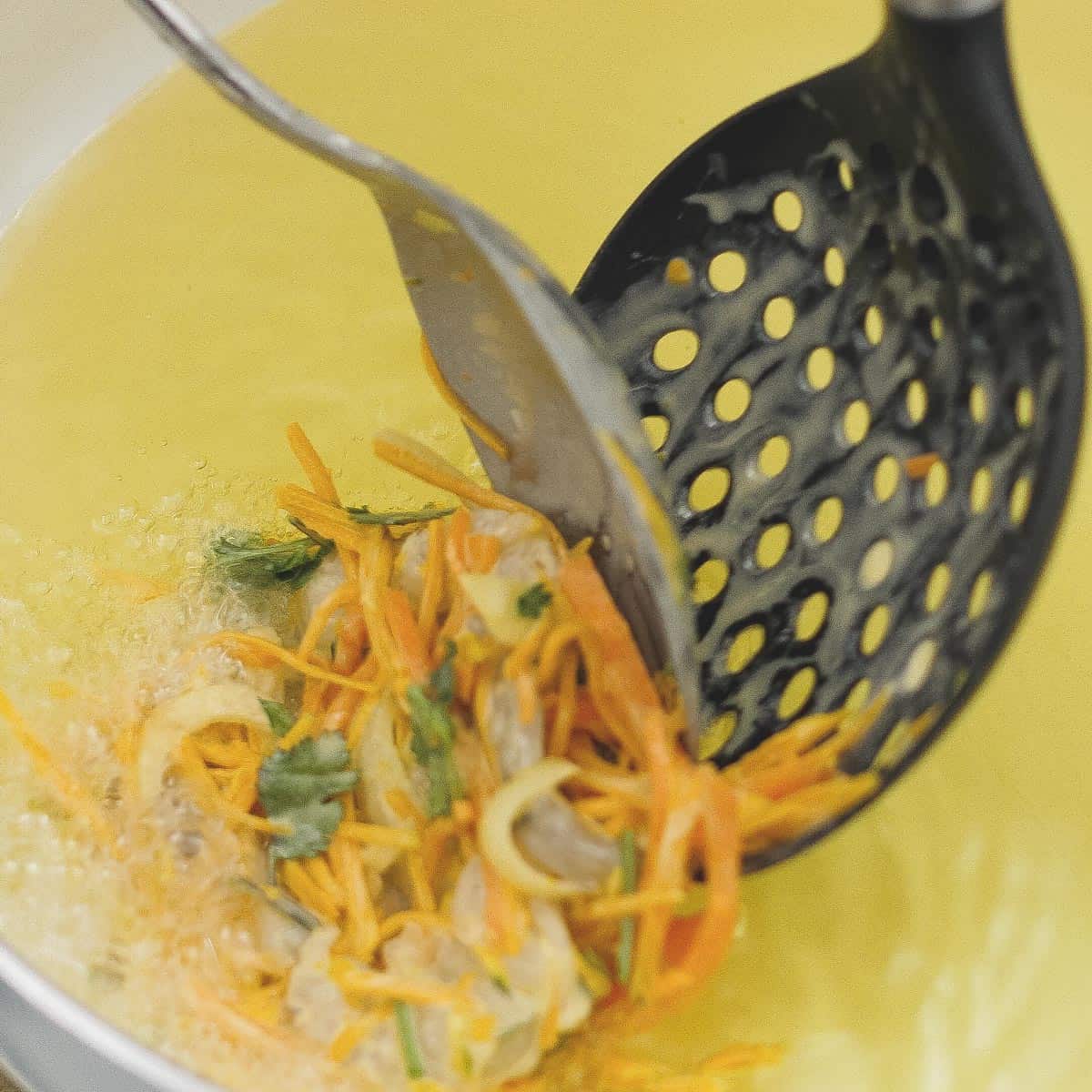 Sliding raw okoy mixture into the hot oil.