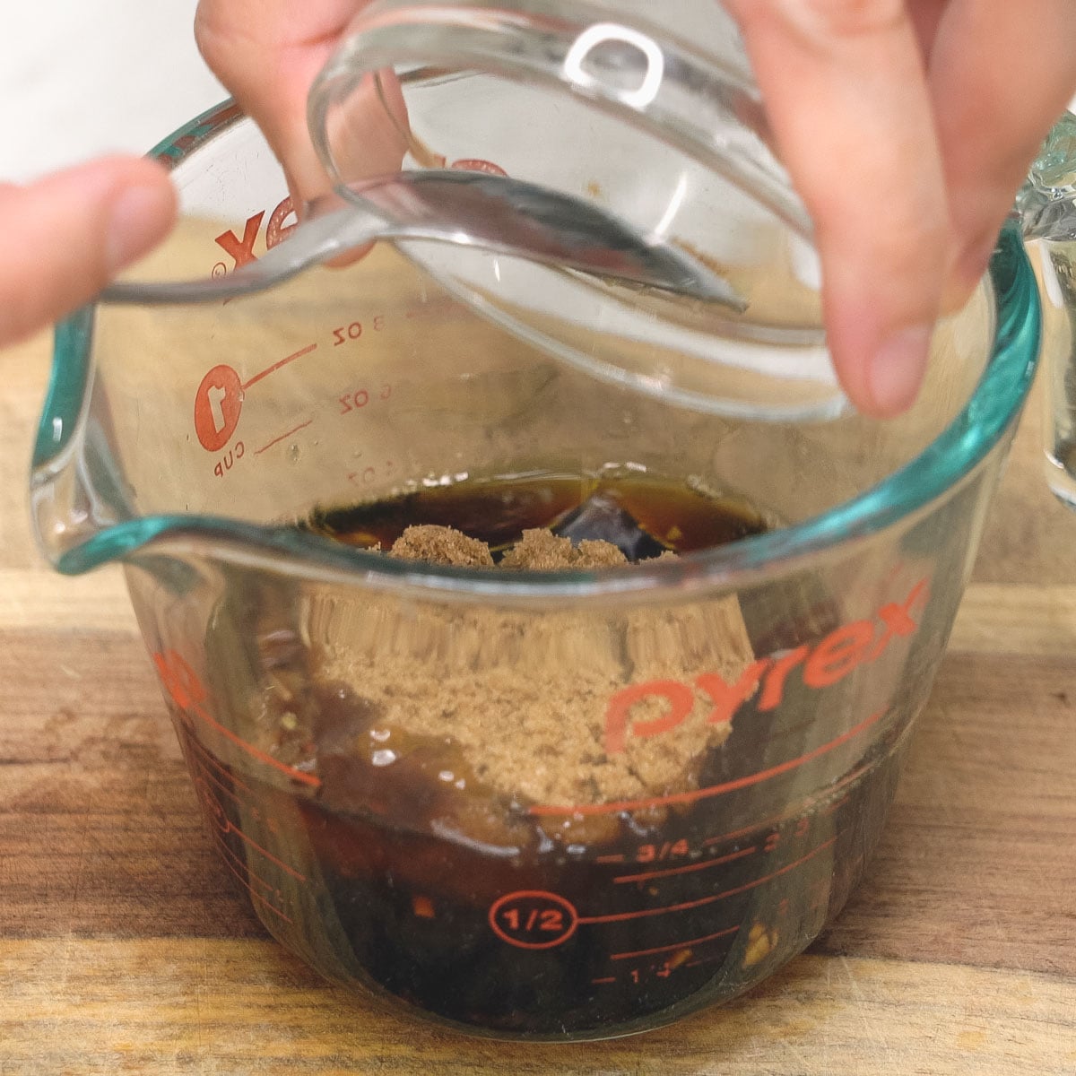 Mixing the marinade ingredients in a measuring cup.