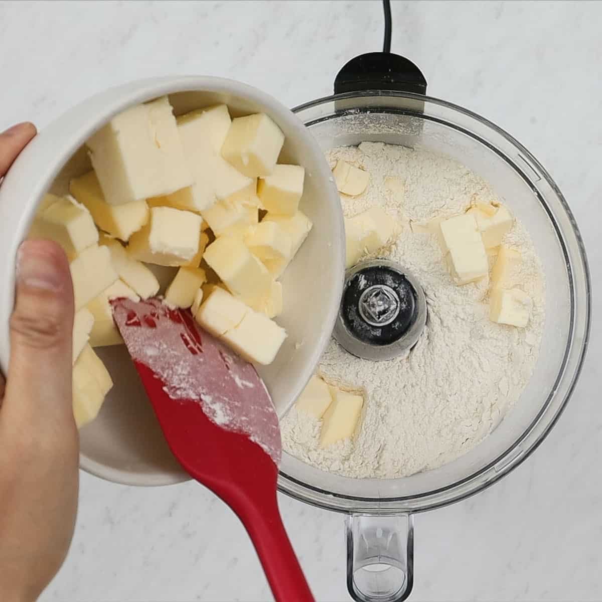 Adding butter to the flour mixture in the food processor.