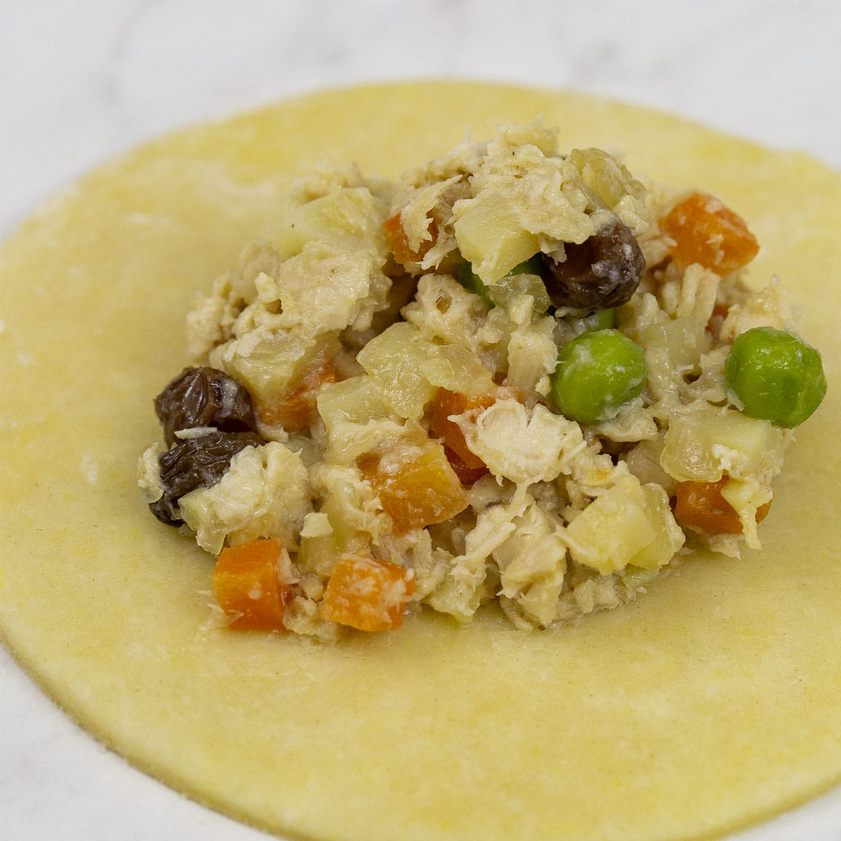 Chicken filling on a round of dough