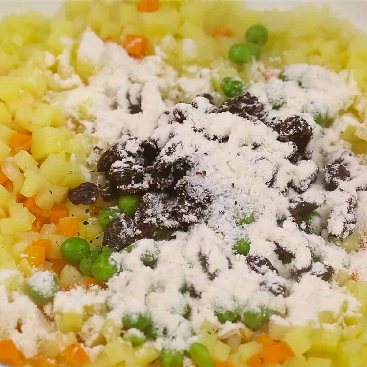 Added peas, raisins, and flour to the potatoes and carrots.