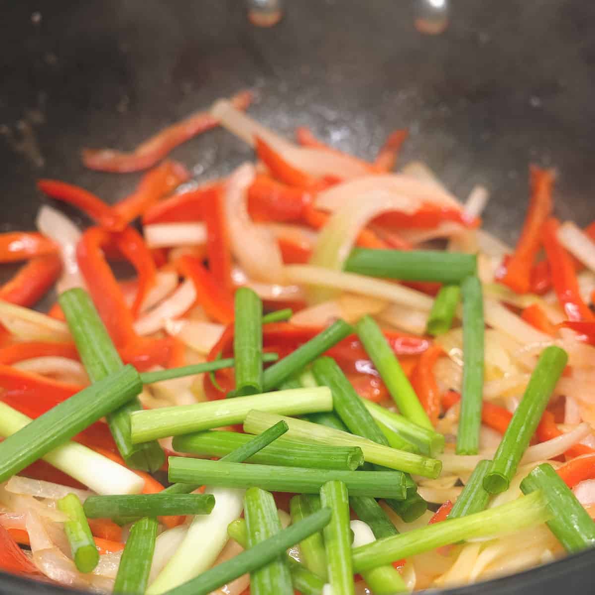 Stir frying the vegetables on the wok.