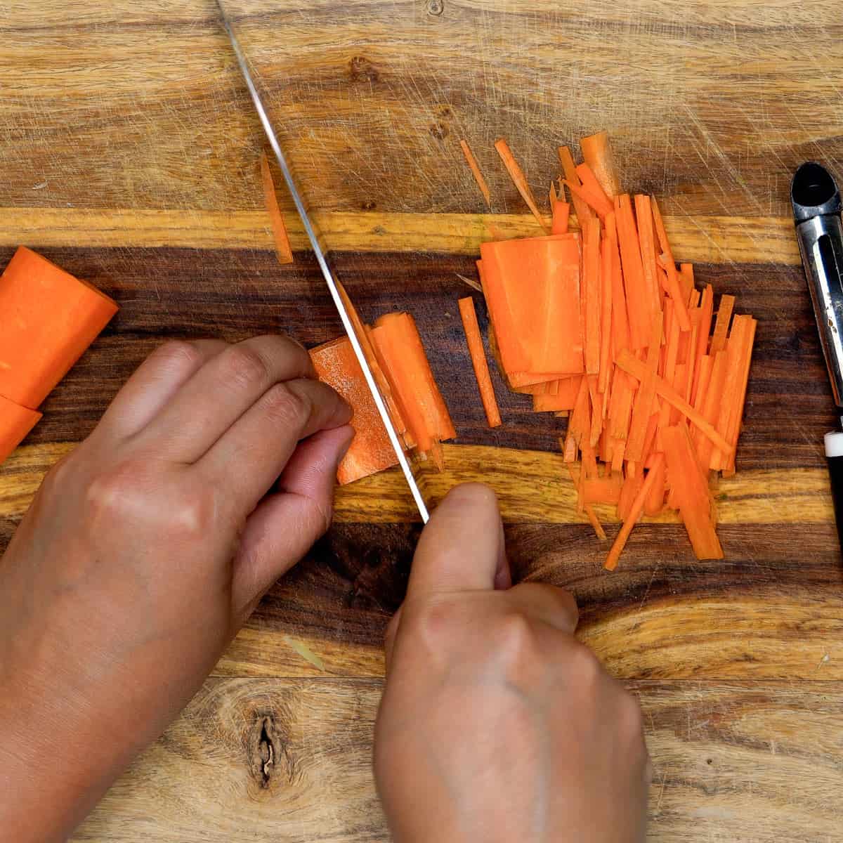 Slicing carrots thinly into matchsticks.
