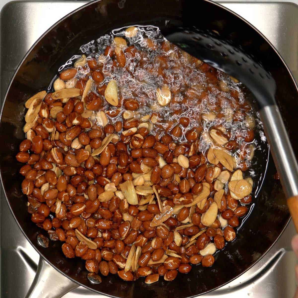 Stirring the peanuts and garlic in oil.