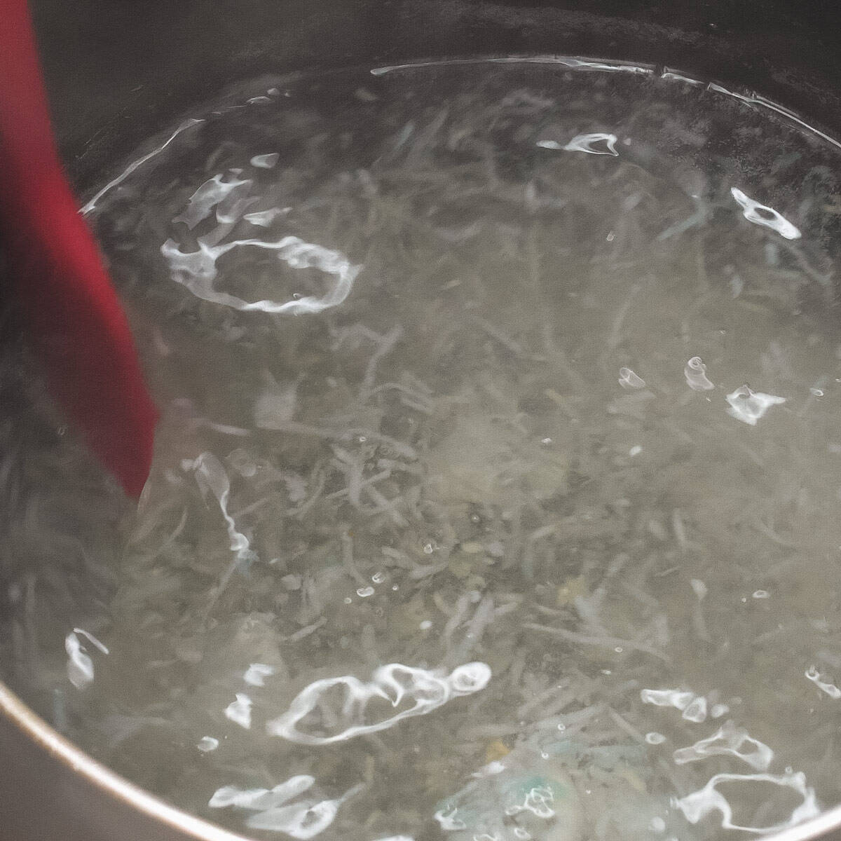Mixing Achara (Pickled Green Papaya) brine in the saucepan.