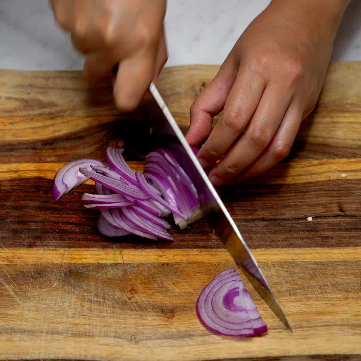 Slicing red onion thinly.