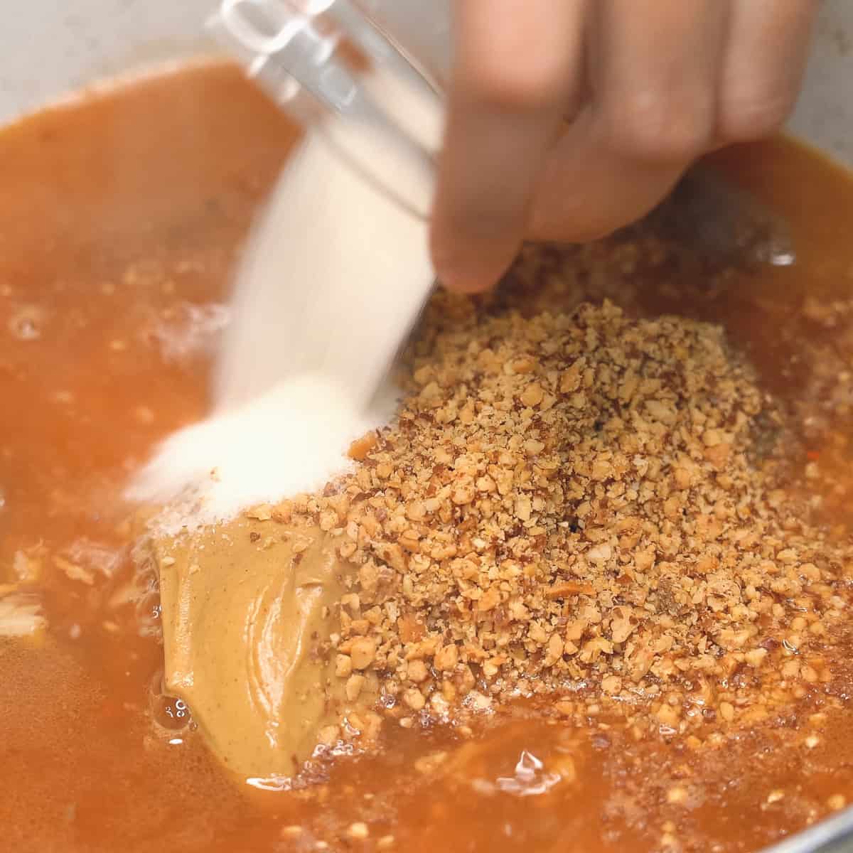 Adding sugar to a pot of stew.