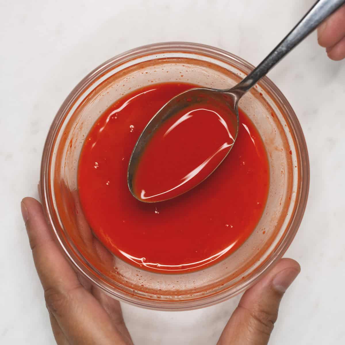 Mixing annatto powder with water in a bowl.