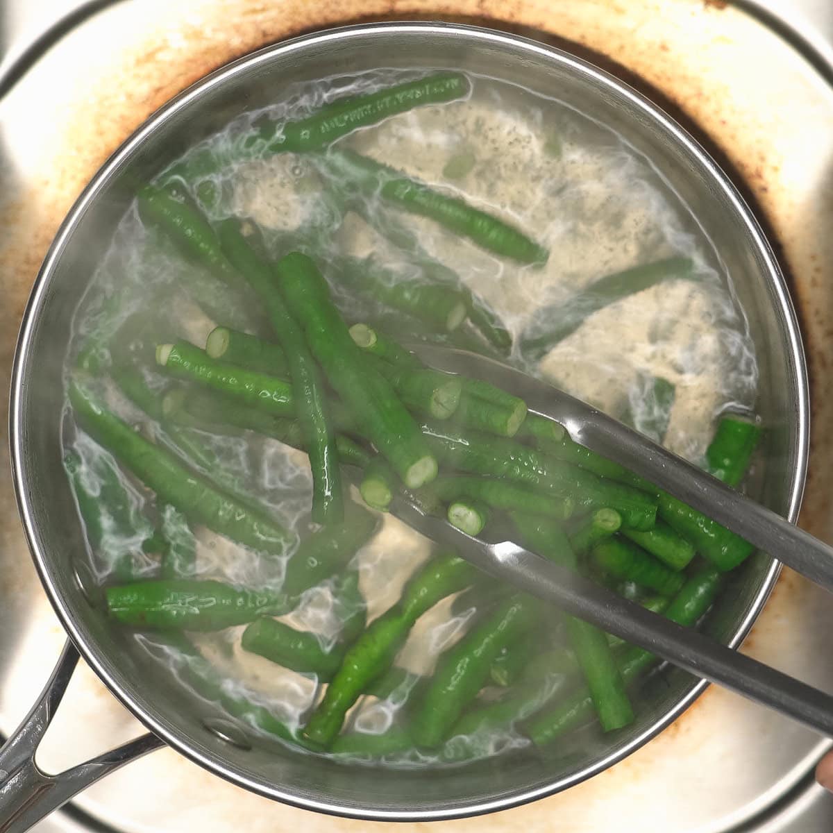 Taking sitaw or string beans out of the boiling water