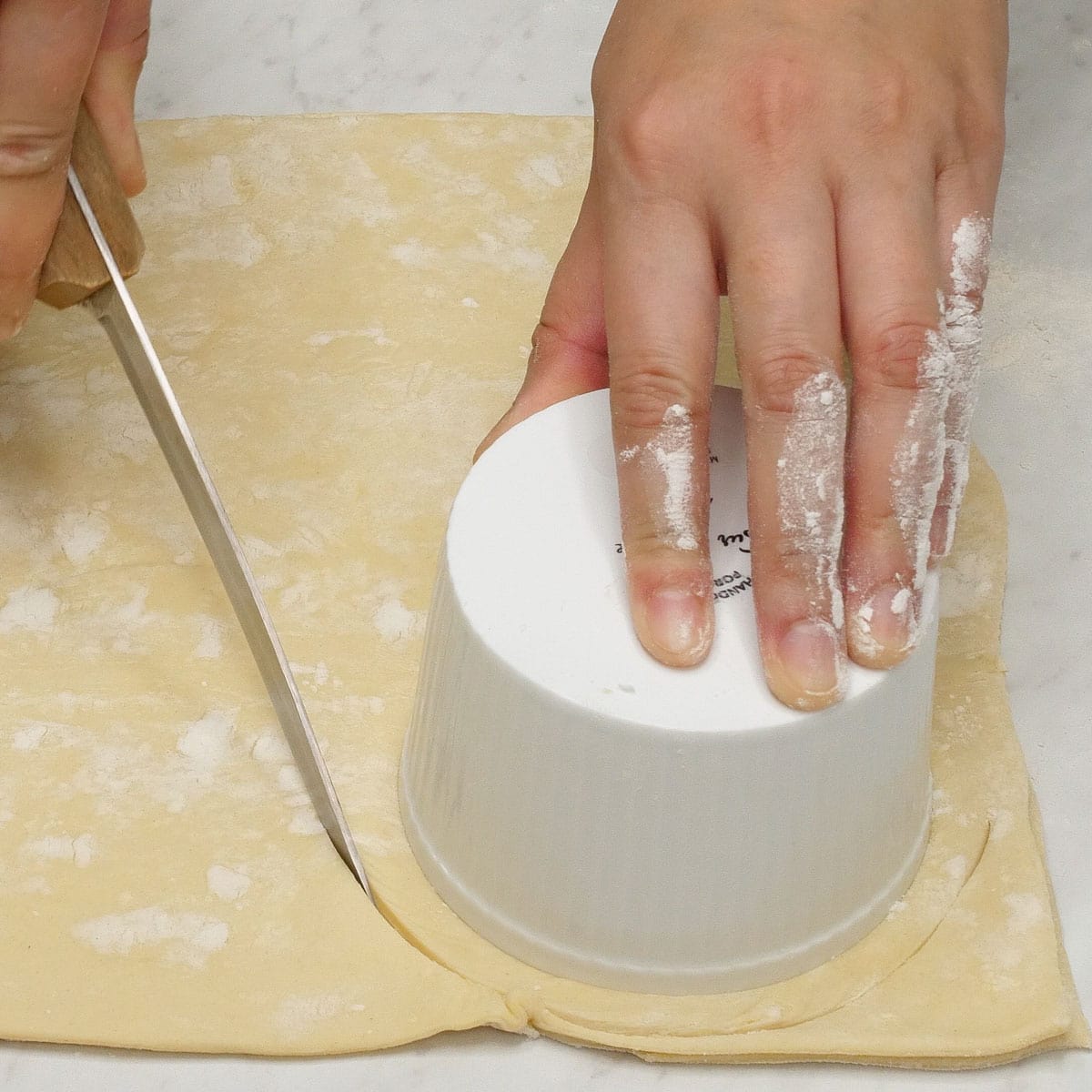 Making cut-outs on the dough using a ramekin.