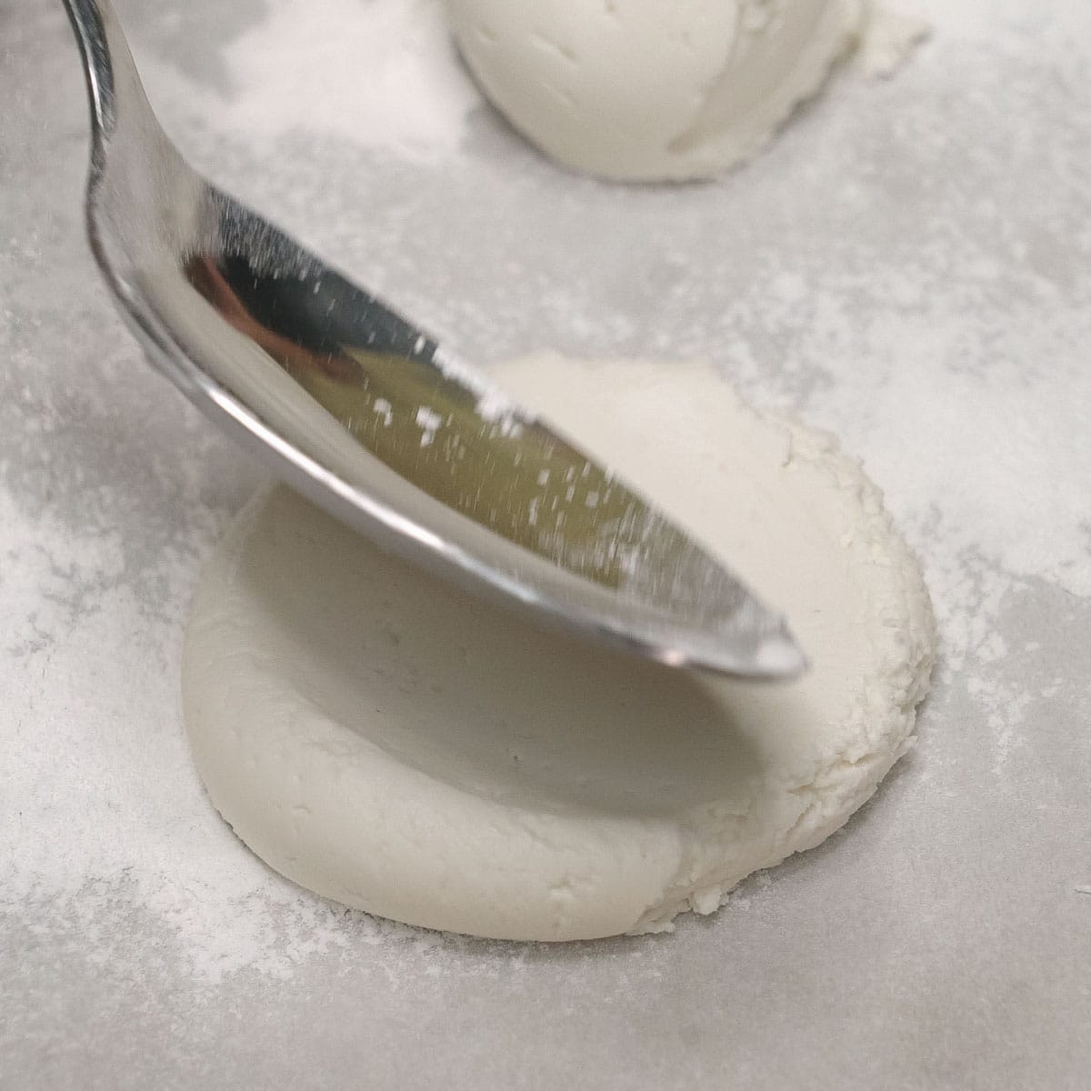 pressing palitaw with the back of a spoon.