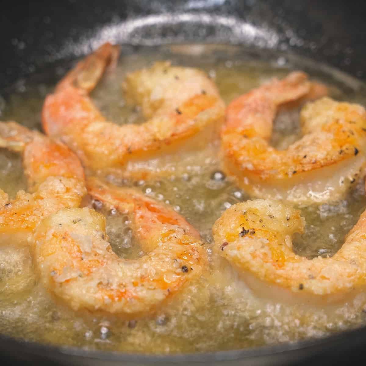 Browned pieces of shrimp in oil.