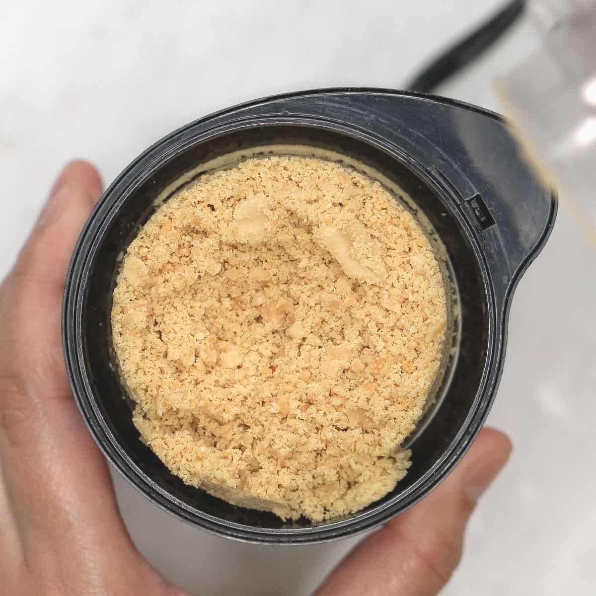 Grinding peanuts in a coffee grinder.