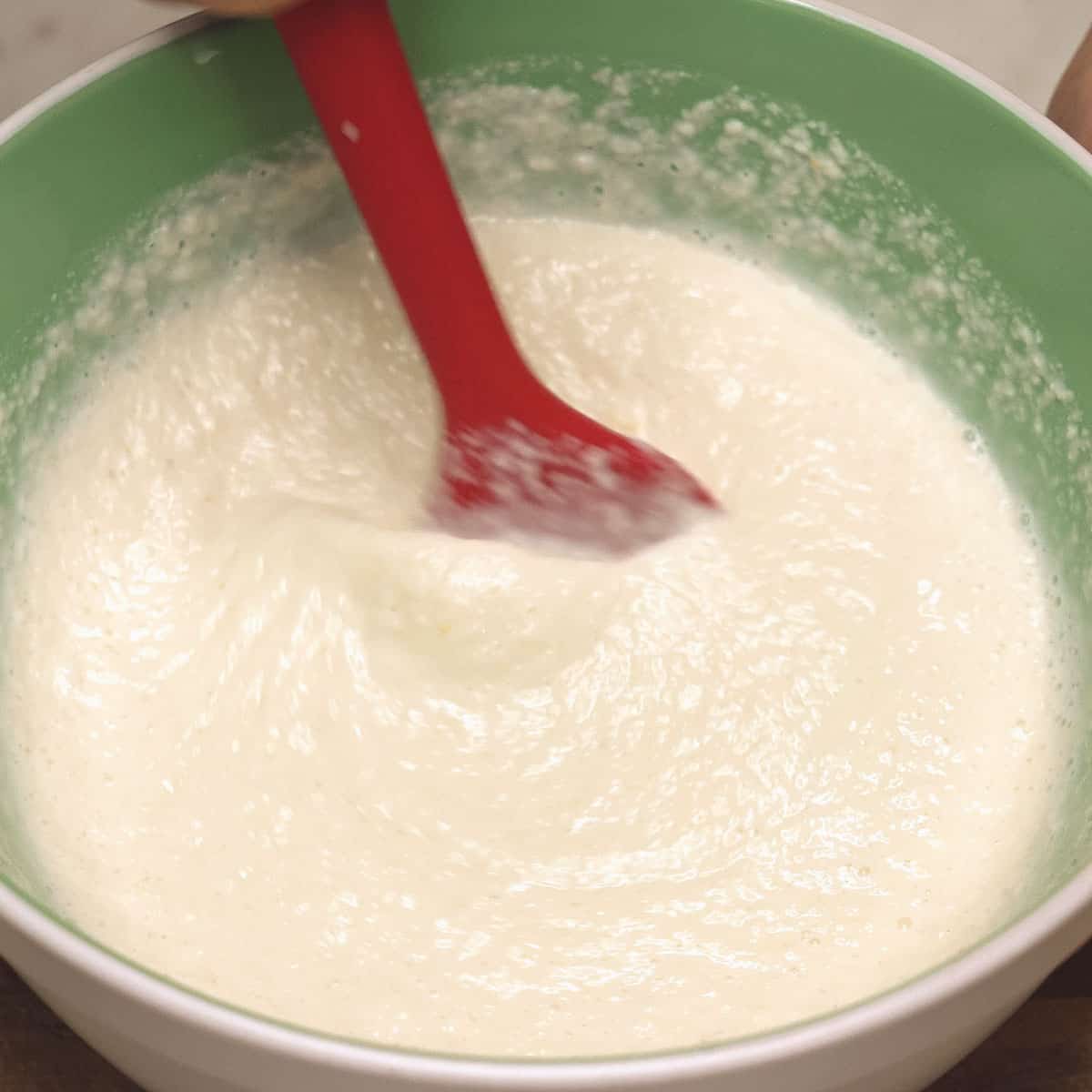 Mixing the cassava mixture with a rubber spatula.