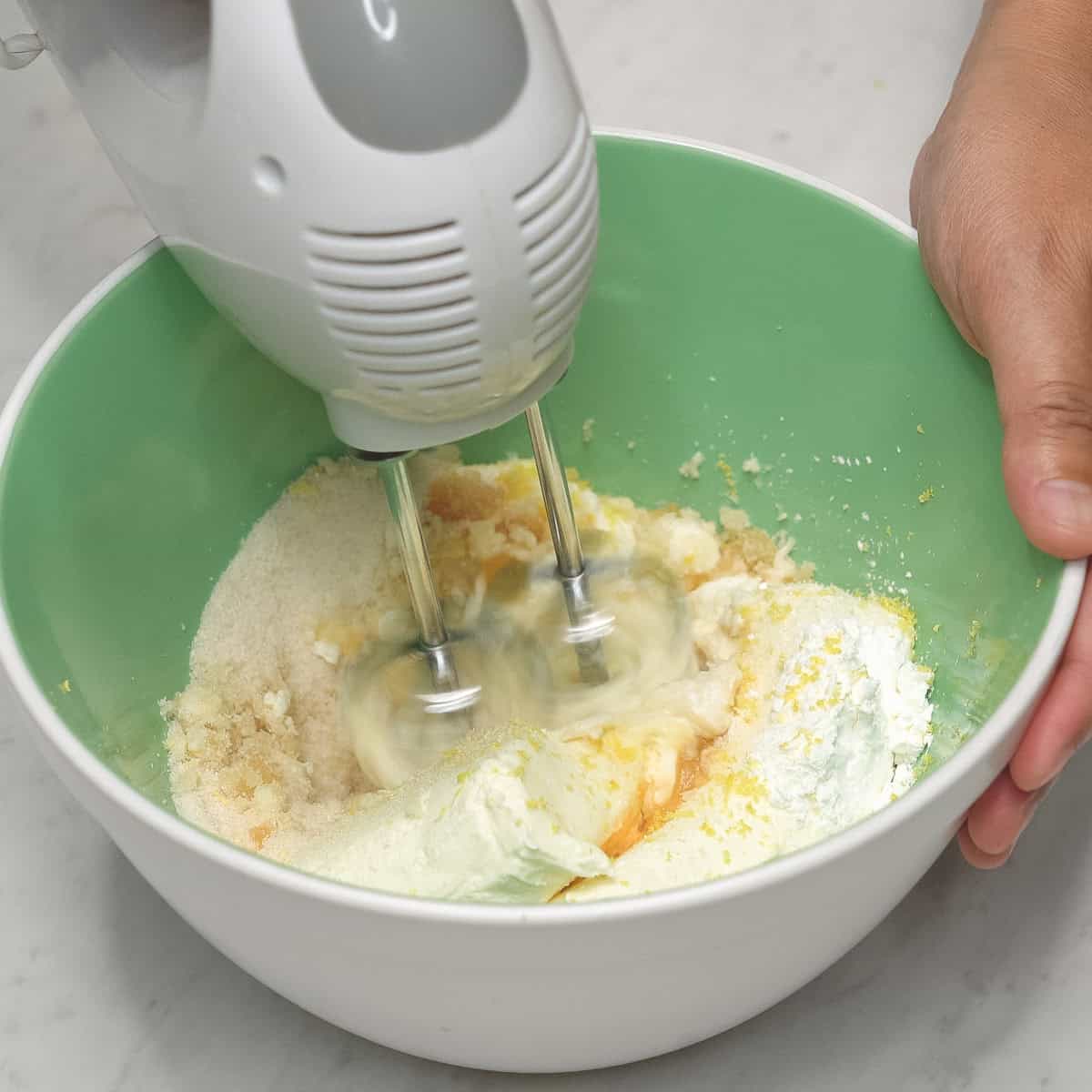 Mixing the ingredients with a hand mixer in a bowl.