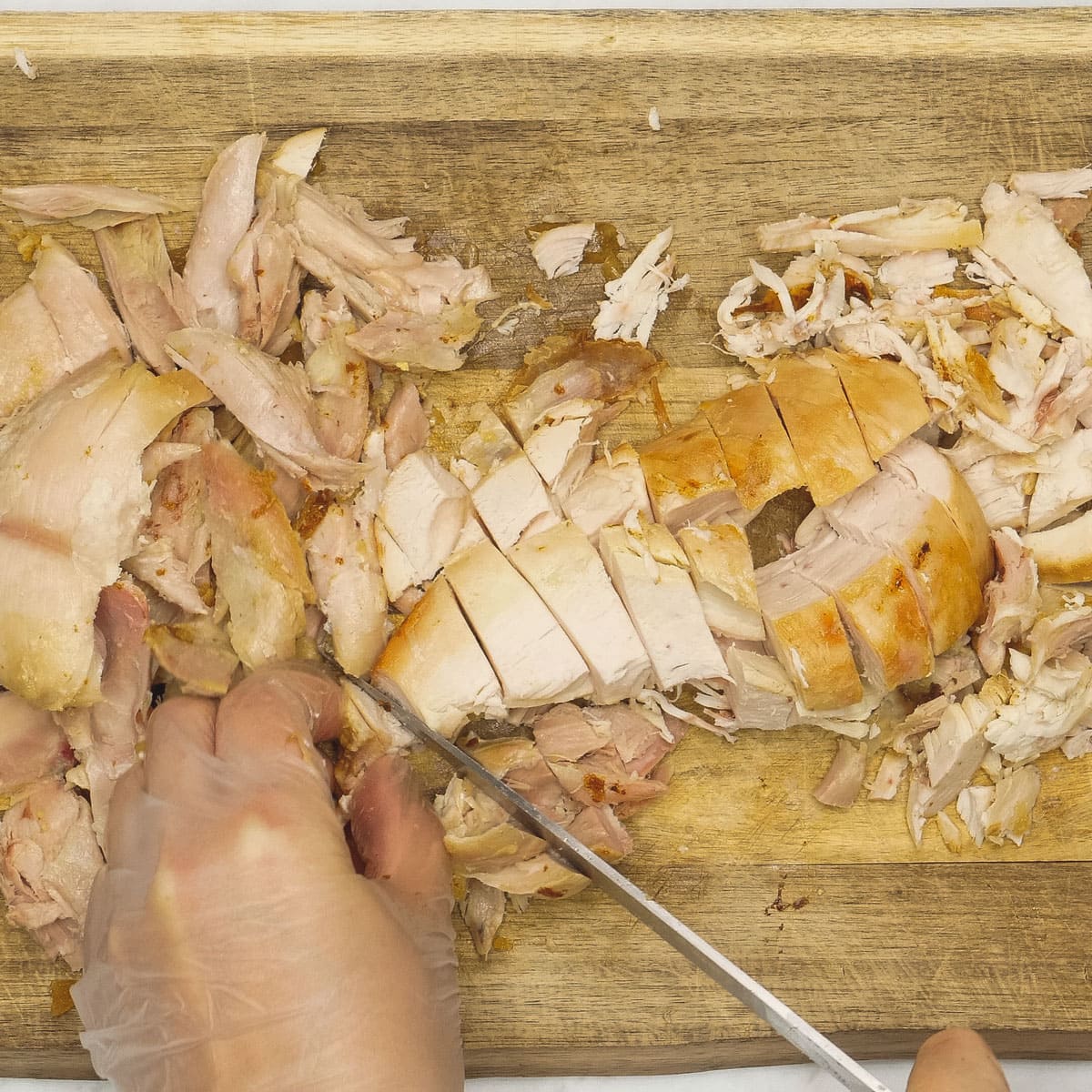 Cutting up chicken on a cutting board.