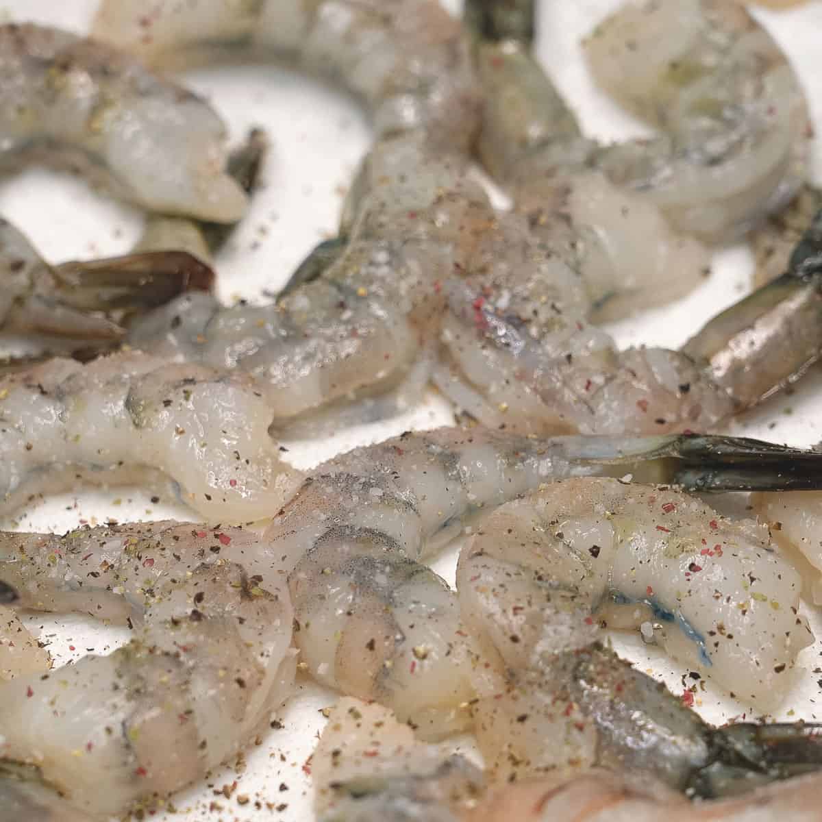 Seasoned shrimp with salt and pepper on a paper towel.