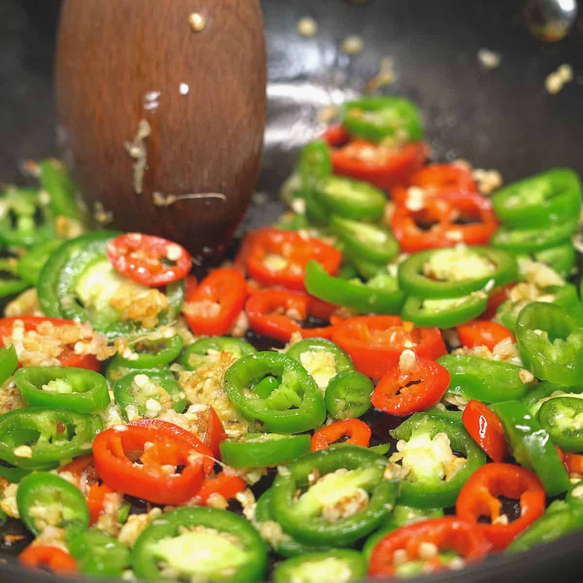 Sauteing ginger and garlic , then added the slices of green and red peppers.