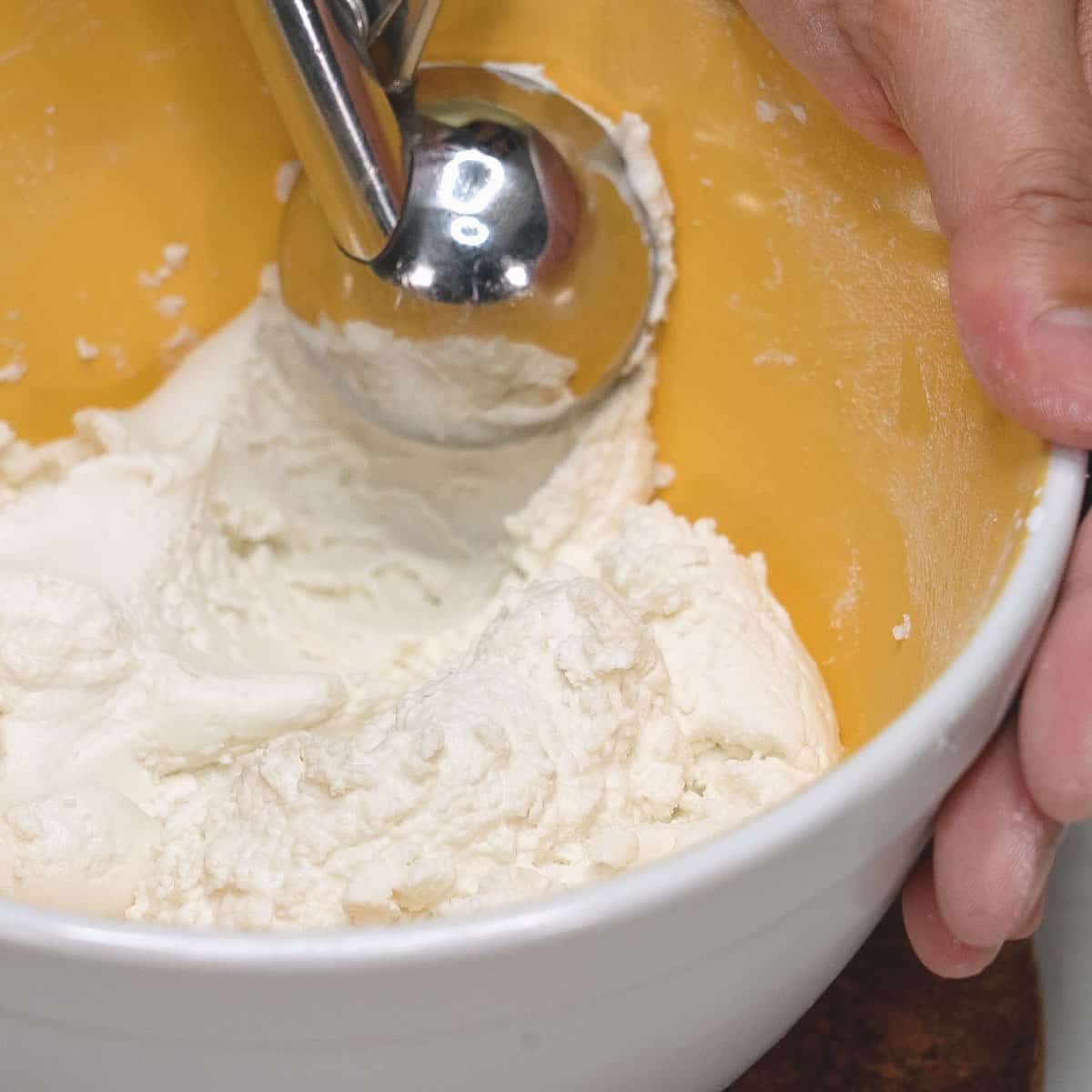 Scooping the dough in the bowl.