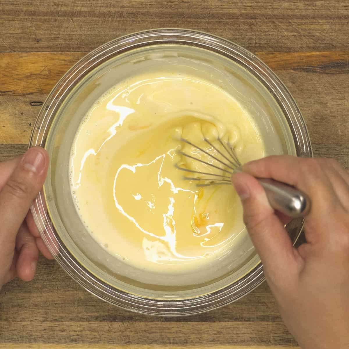 Whisking the custard mixture in the bowl.