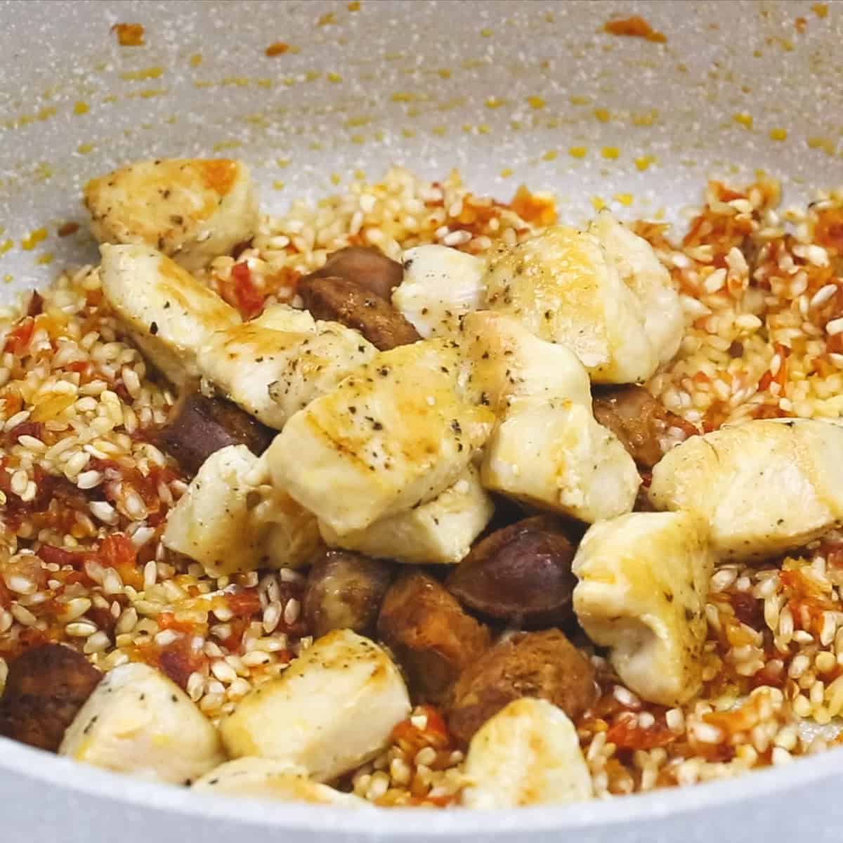 Sofrito, rice, and proteins in the pan.
