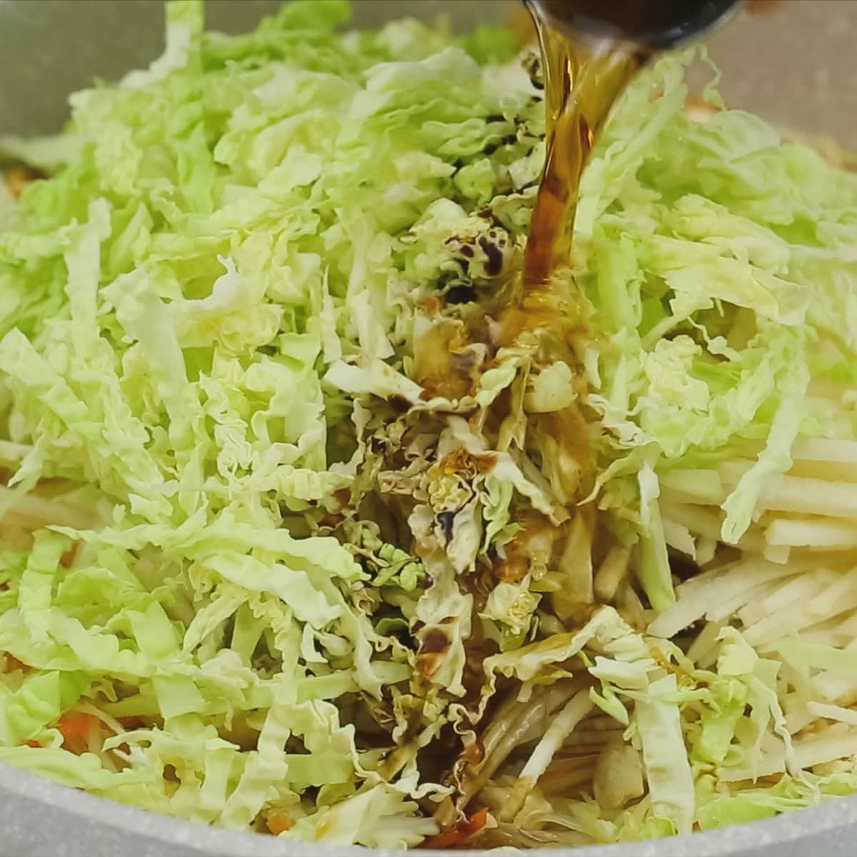Adding the seasonings to the vegetables in the pan.