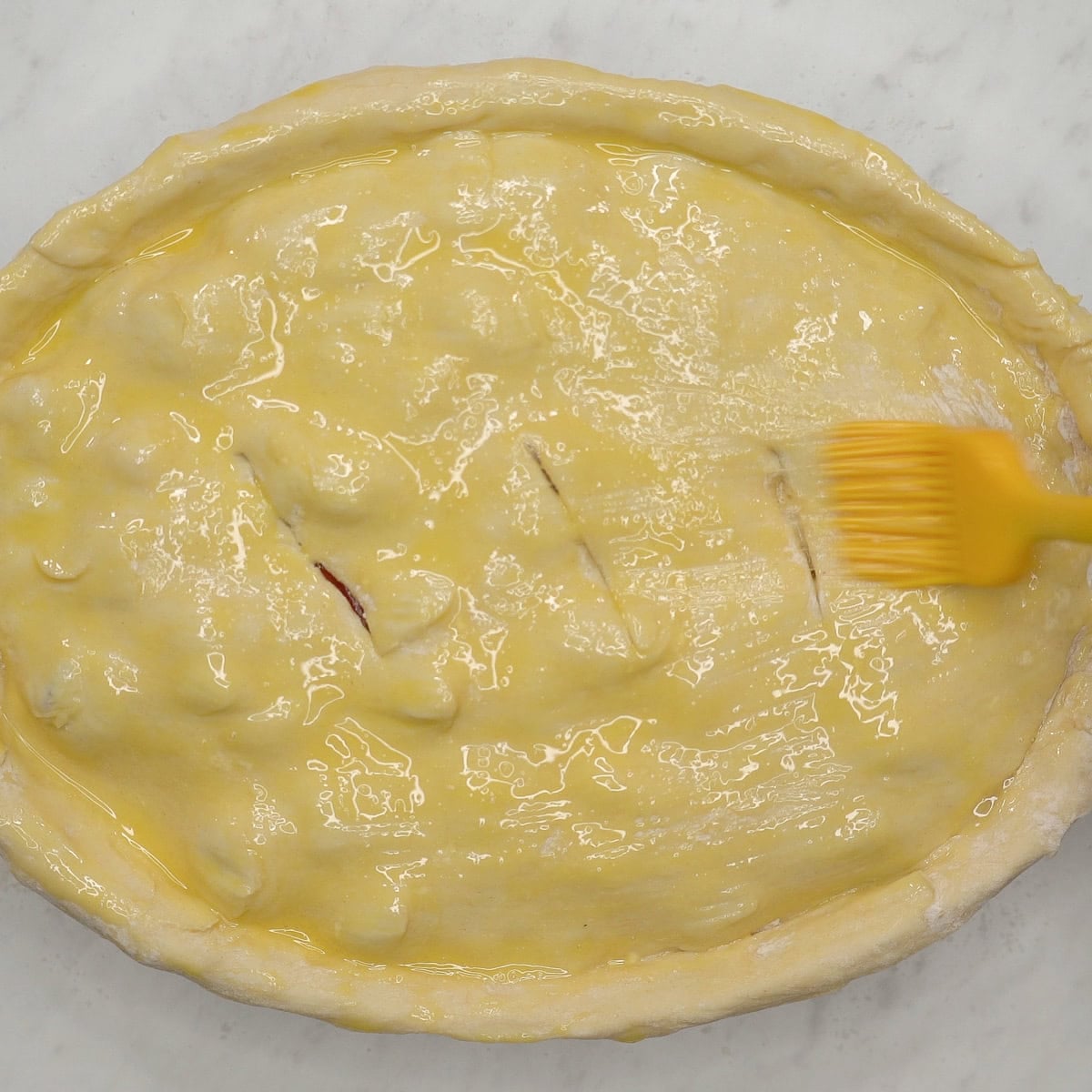 Brushing the puff pastry with egg wash.
