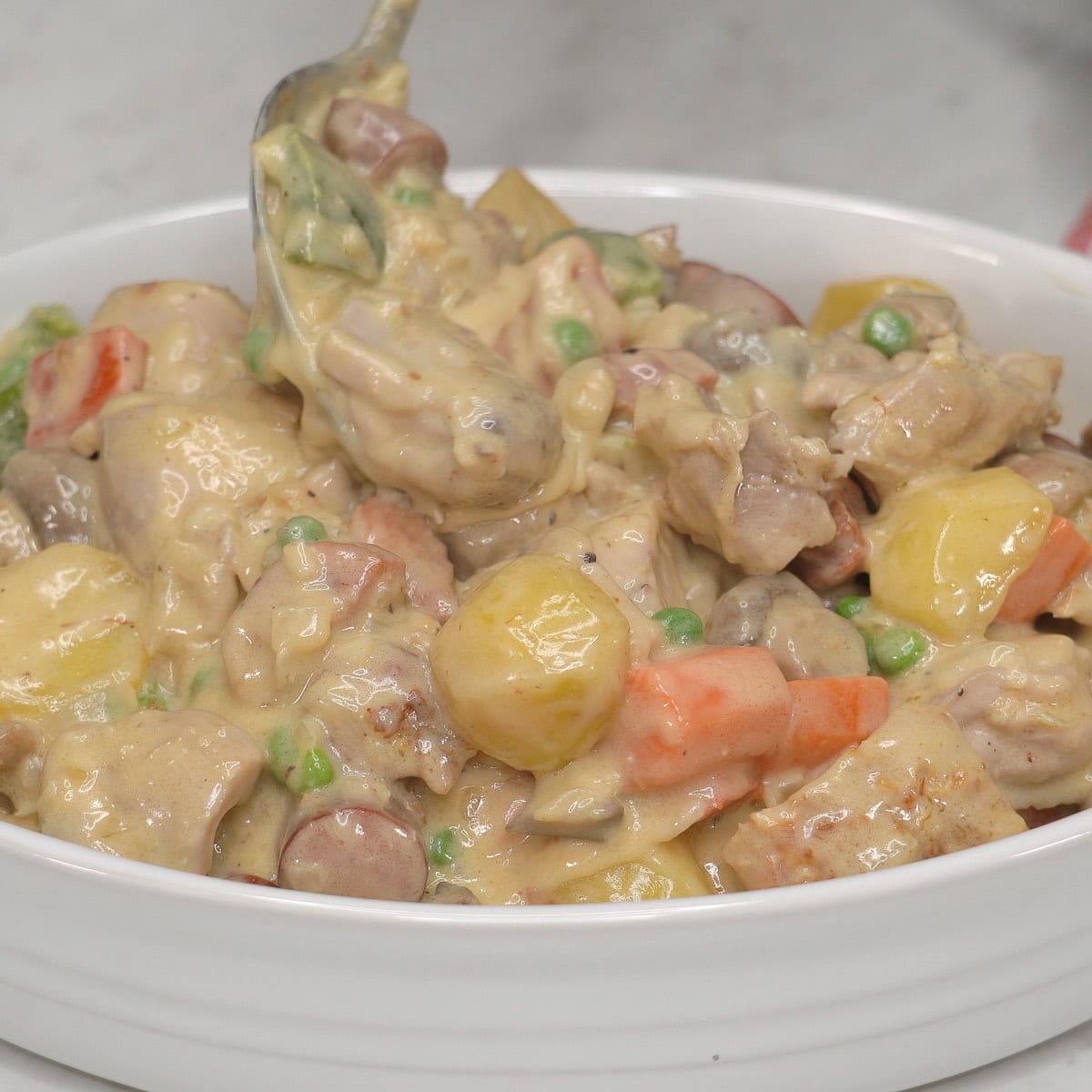 Transferring Chicken Pastel to the casserole dish.