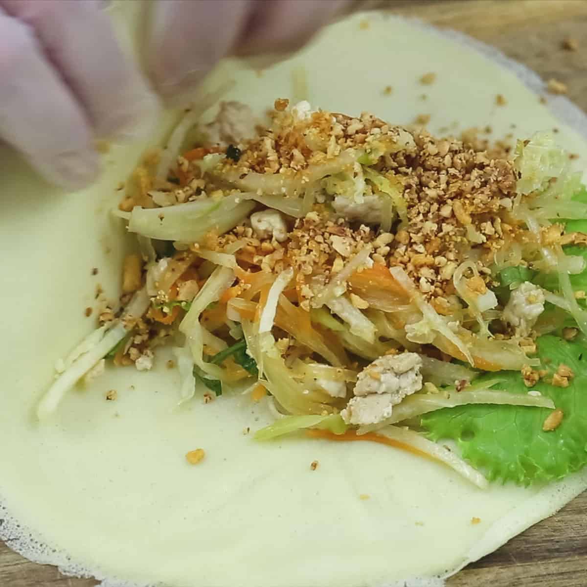 Folding the bottom half of the wrapper over the filling.