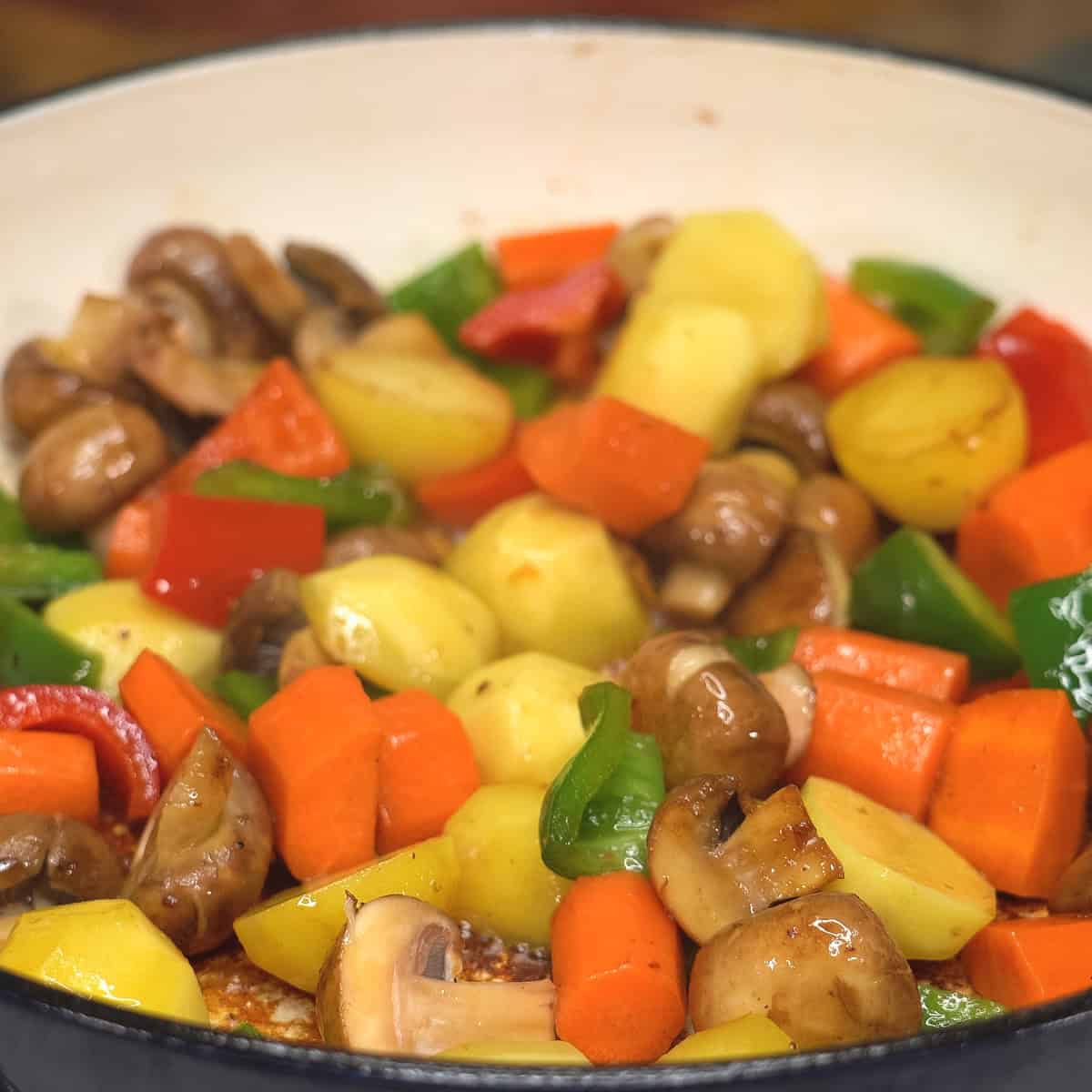 Searing vegetables in a saute pan.