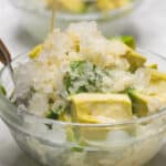 Sliced avocado, milk, and shaved ice in a bowl.