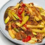 Ginisang sayote sauteed chayote on a plate with a spoon.