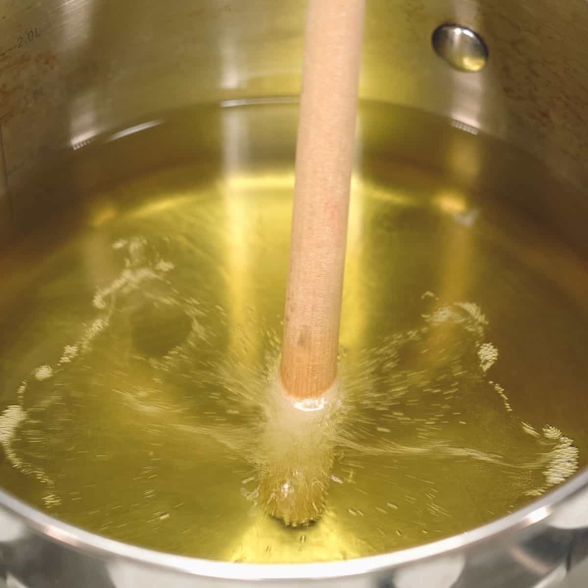 Checking the oil temperature by dipping a wooden stick.