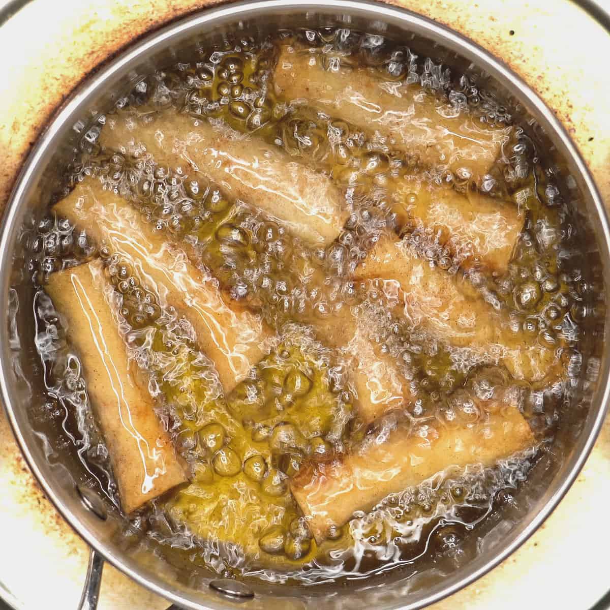 Frying the lumpia in the hot oil.