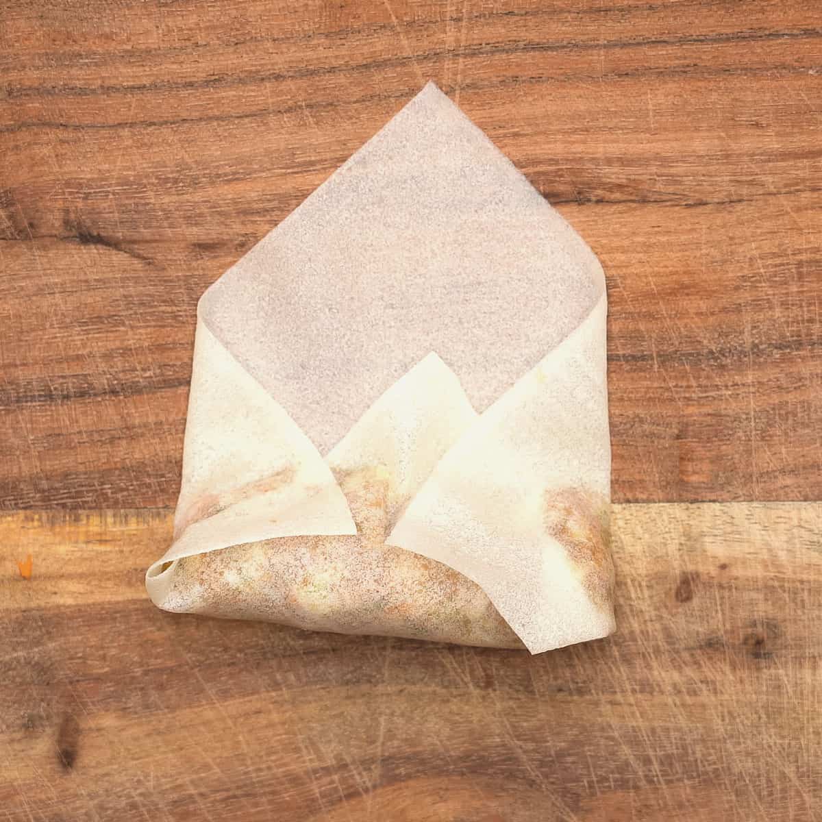 Tucking the sides in to enclose the lumpia.