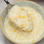 Ginatang mais in a bowl scooped by a spoon.