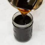 Brown sugar syrup being poured in a jar.