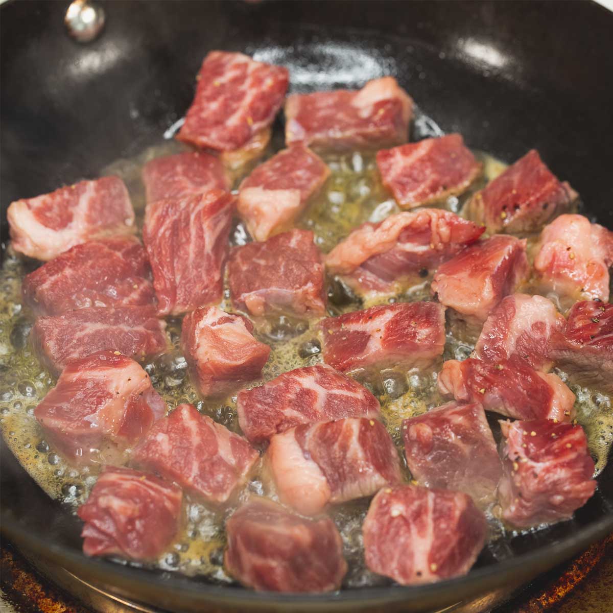 Searing the beef cubes in the wok.