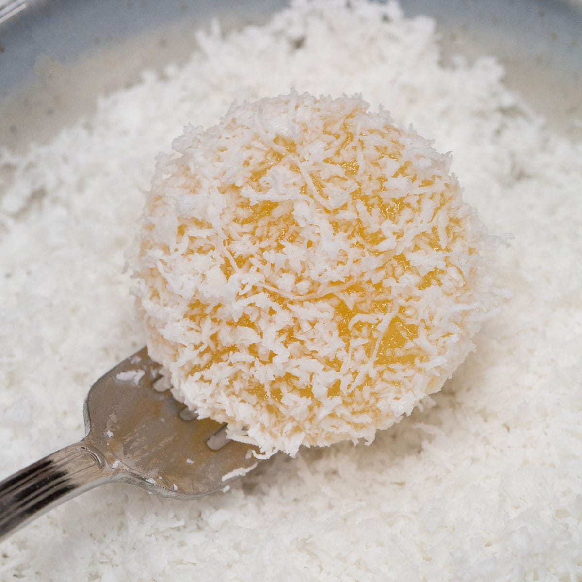 Coating the Pichi-Pichi with grated coconut.