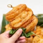 Holding Filipino banana fritters with a banana leaf.
