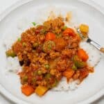 Filipino picadillo topped on rice on a plate.