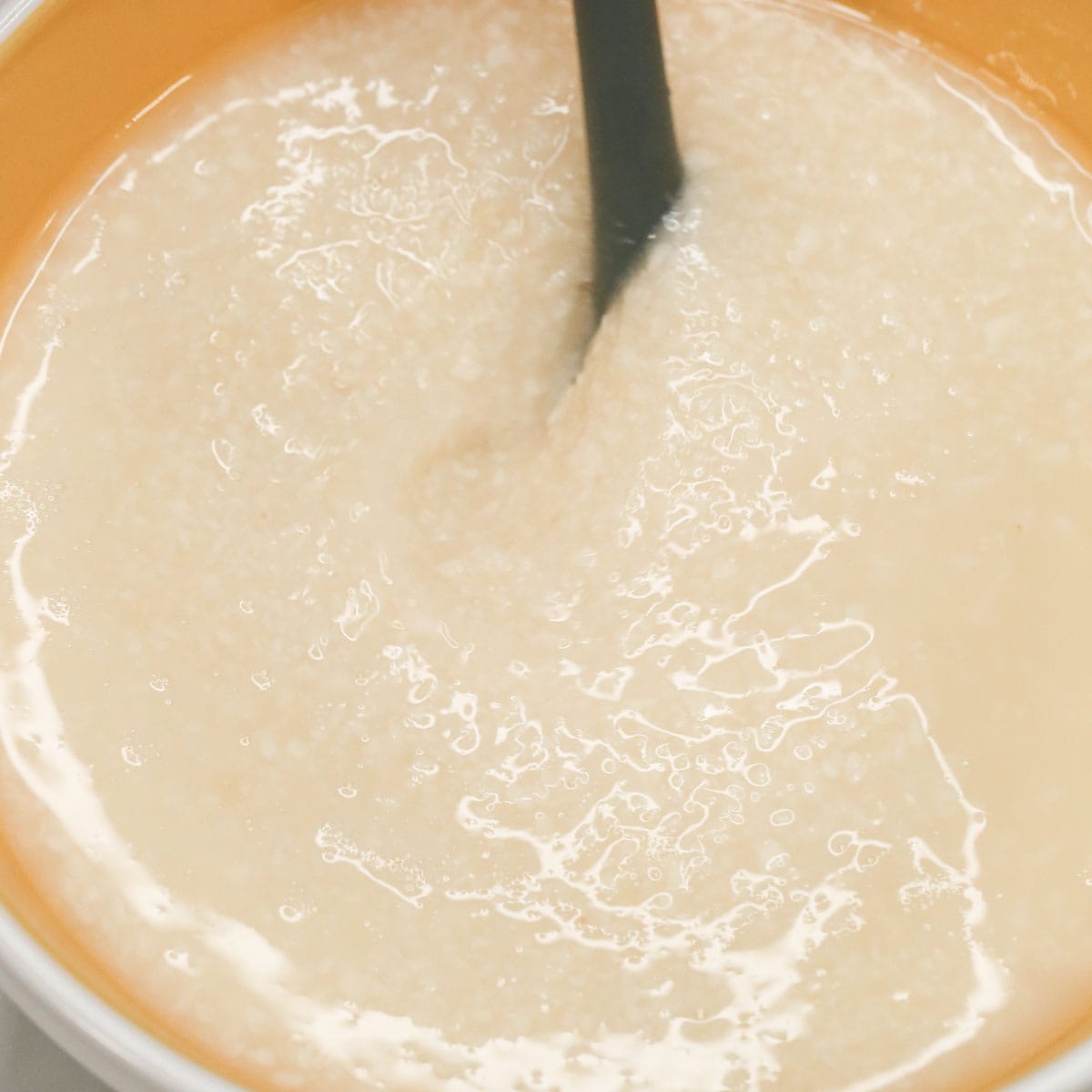 Mixing the ingredients for Pichi-Pichi (Steamed Cassava Cakes) in a bowl.