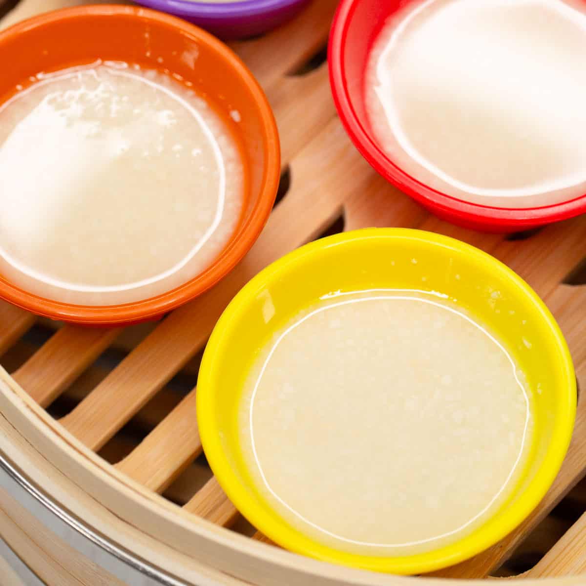 Pichi-Pichi (Steamed Cassava Cakes) mixture in the molds in the steeamer basket.